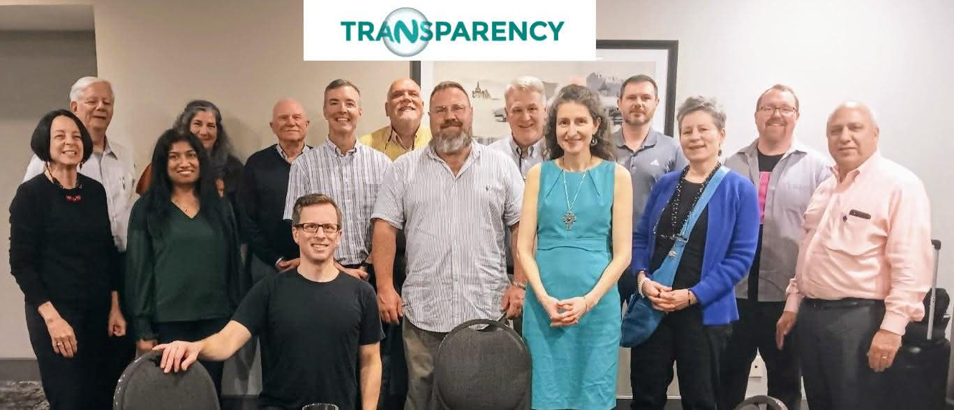 Group photo of Sara Grillo and a 14 flat-fee financial advisors at a group meetup. They are gathered in what appears to be an office conference room.